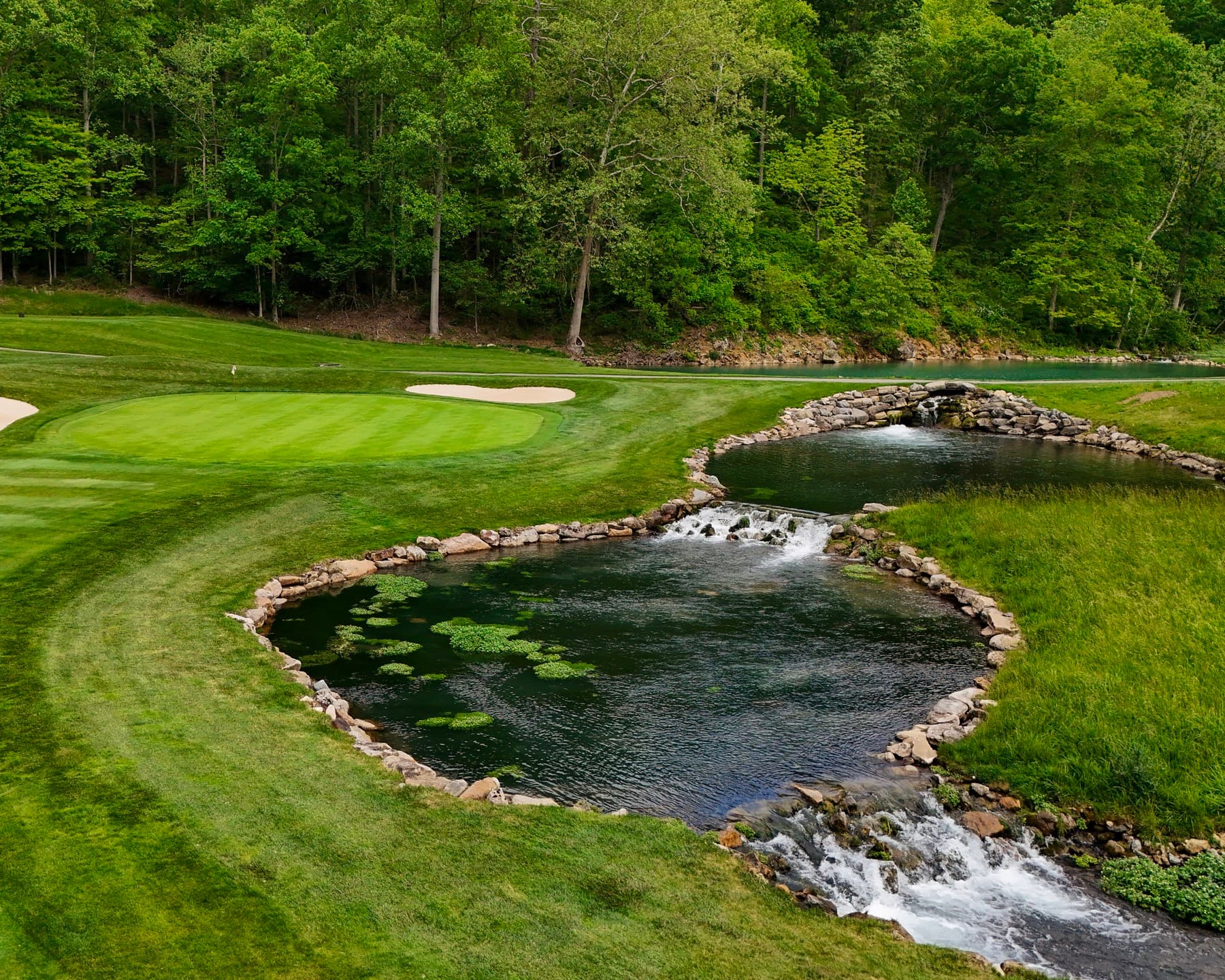 Golf green beside pond and waterfall