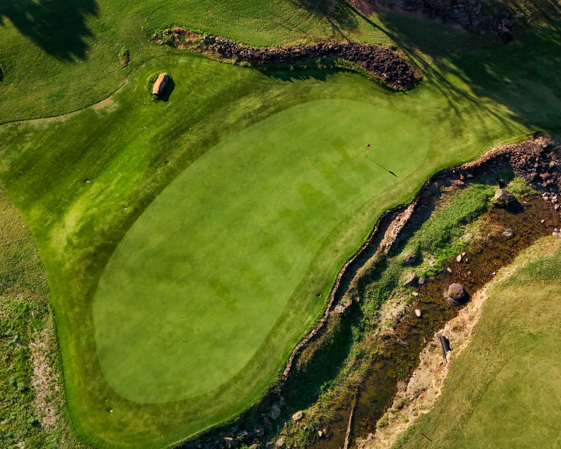 Aerial golf green with stream and rock walls